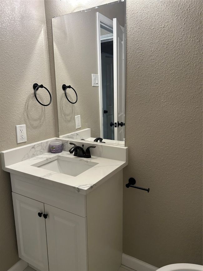 Half bathroom featuring vanity and a textured wall | Image 26