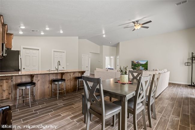 Dining space with wood finish floors, ceiling fan, lofted ceiling, baseboards, and recessed lighting | Image 26