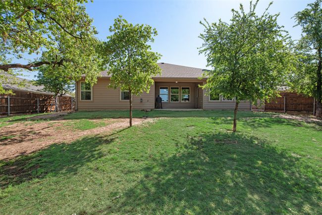 Back of property featuring a shingled roof, a yard, and a fenced backyard | Image 31