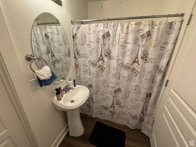 Bathroom with a shower with curtain and wood finished floors | Image 10