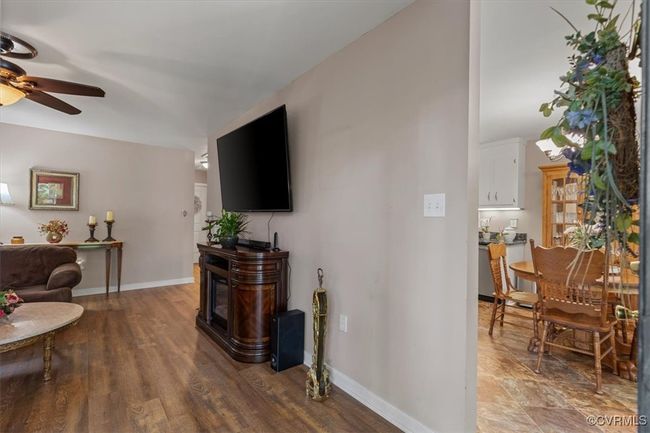 Living room with a ceiling fan, baseboards, and wood finished floors | Image 5