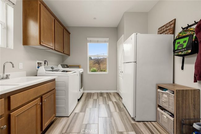 Large laundry room on main floor with a full size fridge | Image 28