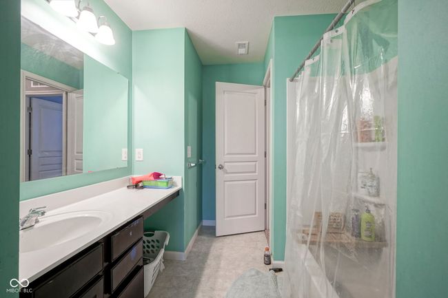full bathroom featuring baseboards, a shower with shower curtain, vanity, and a textured ceiling | Image 31