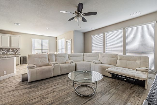 Living room with light wood-type flooring and ceiling fan | Image 15