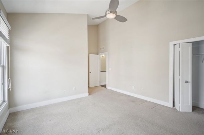 Unfurnished bedroom featuring high vaulted ceiling, a ceiling fan, a closet, carpet flooring, and baseboards | Image 24