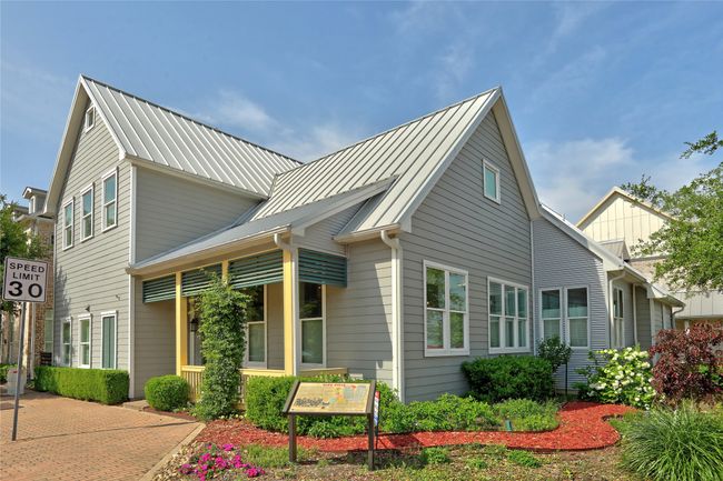 View of home's exterior from the corner featuring its architectural style, welcoming front porch and the durable metal roof. | Image 28