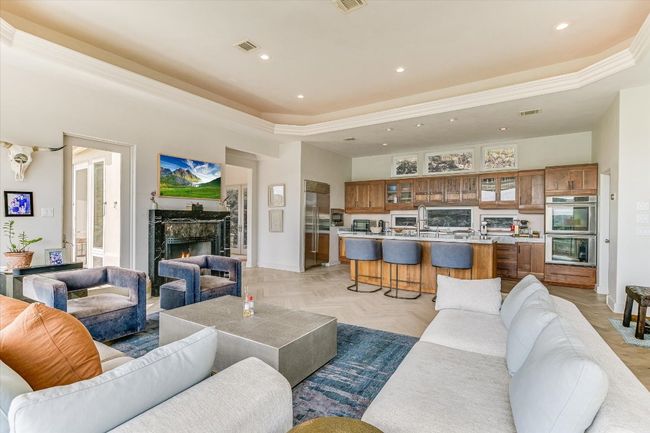 Living area featuring a tray ceiling, recessed lighting, a fireplace, and crown molding | Image 9