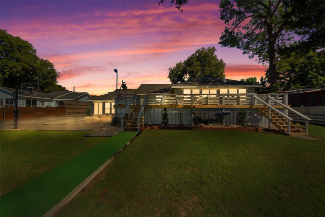 Back of property with stairway, a wooden deck, and driveway | Image 10