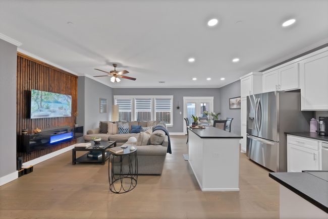 Living room with ceiling fan, crown molding, recessed lighting, baseboards, and light wood-type flooring | Image 15