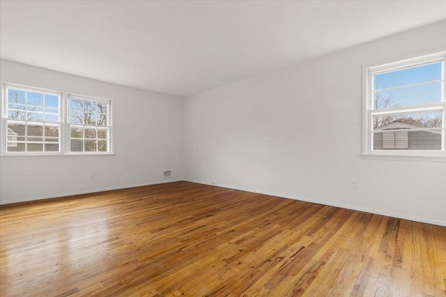 Spare room featuring plenty of natural light, visible vents, baseboards, and light wood-style flooring | Image 17