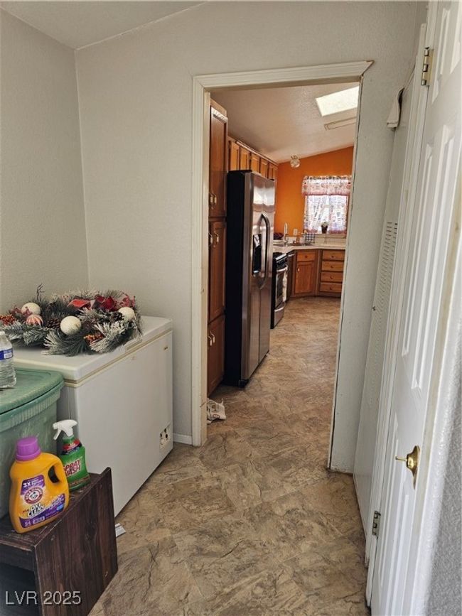 Kitchen featuring range, light countertops, brown cabinetry, and fridge | Image 28