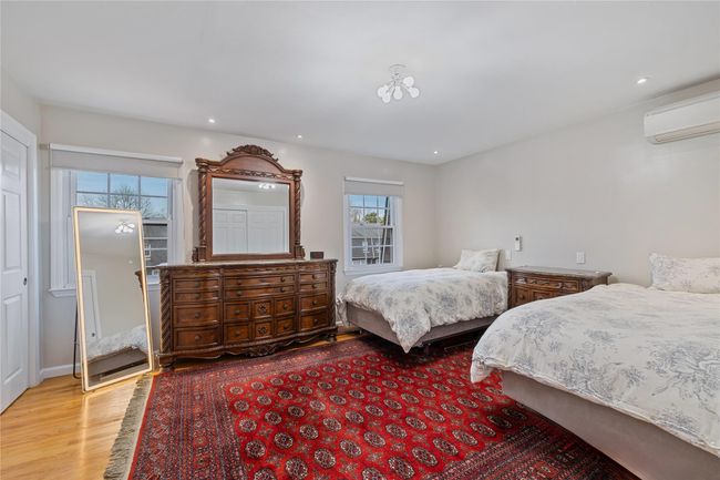 Bedroom with wood finished floors, recessed lighting, and a wall unit AC | Image 22