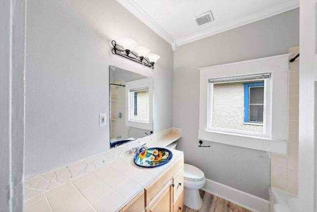 Bathroom featuring crown molding, toilet, wood finished floors, vanity, and baseboards | Image 15