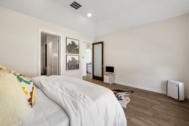 Bedroom with wood finished floors and vaulted ceiling | Image 22