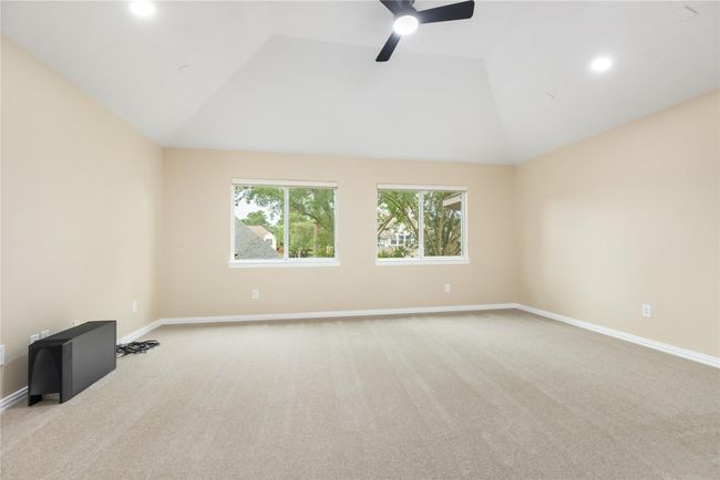 This bright and spacious flex room boasts soaring ceilings, a ceiling fan, and two oversized windows that fill the space with abundant natural light, creating an open and airy atmosphere perfect for play, work, or relaxation. | Image 27