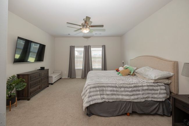 Bedroom featuring light carpet and a ceiling fan | Image 30