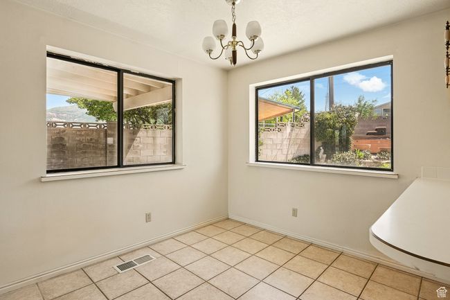 Empty room featuring a chandelier and light tile patterned floors | Image 11