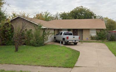 Ranch-style home featuring a front lawn and a garage | Image 1