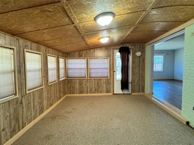 Spare room featuring vaulted ceiling, hardwood / wood-style floors, and wooden walls | Image 15