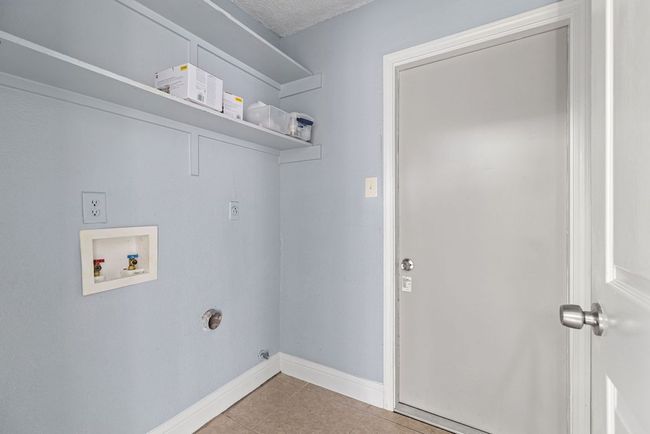 The laundry room is tucked just off the main hallway—a true utility space that keeps the chores contained and out of sight. | Image 31