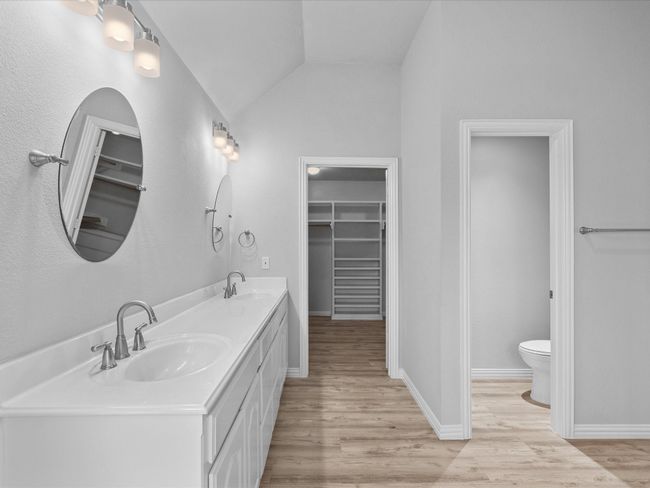 Master full bath featuring lofted ceiling, tiled shower, double-sink vanity, laminated floors and plenty of natural light | Image 24
