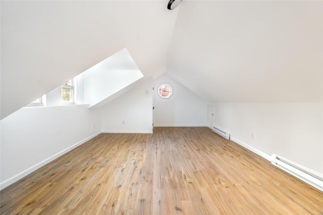 Additional living space featuring baseboards, hardwood / wood-style flooring, lofted ceiling, and a baseboard radiator | Image 16