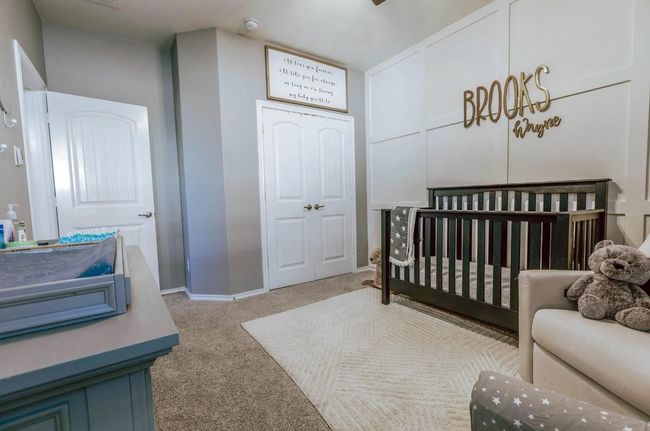 Carpeted bedroom featuring a nursery area, a closet, and baseboards | Image 10