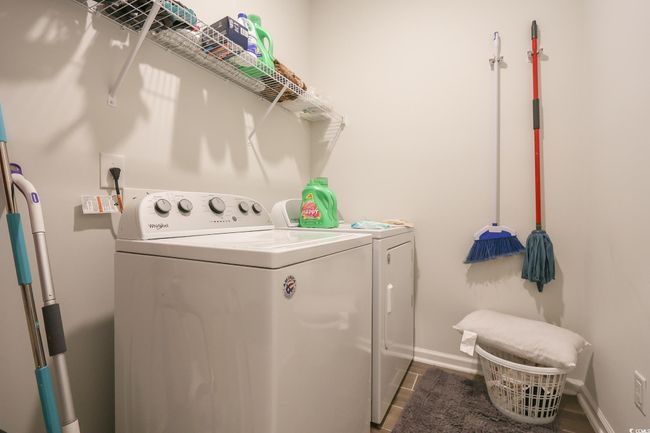 Clothes washing area featuring laundry area, washing machine and dryer, and baseboards | Image 23