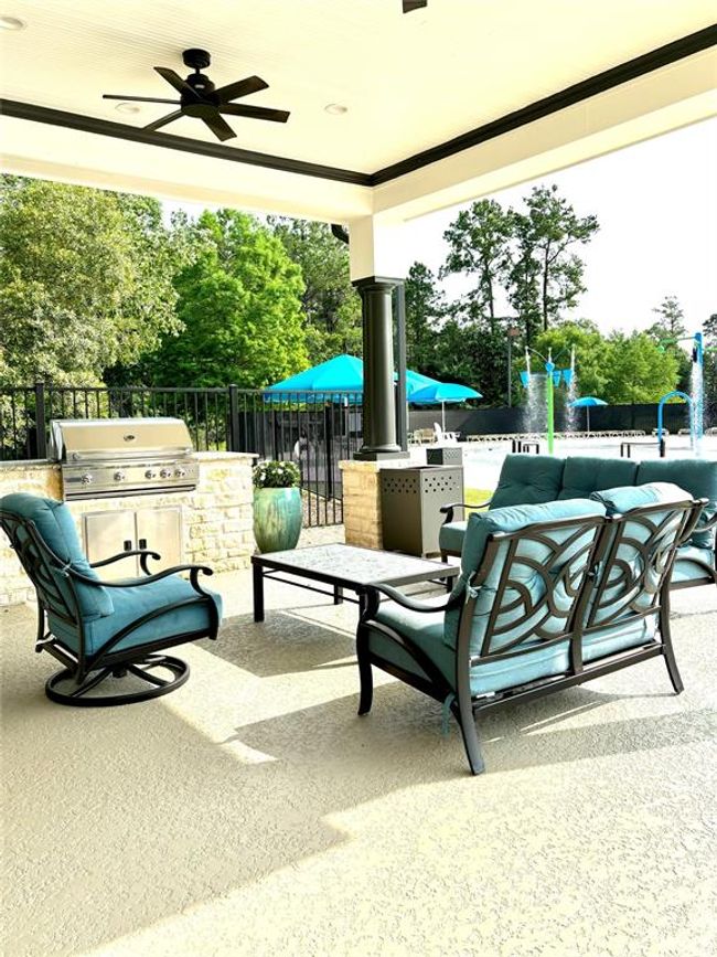 The Clubhouse at The Falls at Imperial Oaks features a covered outdoor lounge with built-in BBQ grills, comfortable seating, and ceiling fans—ideal for relaxing or hosting gatherings near the splash pad and pool. | Image 47