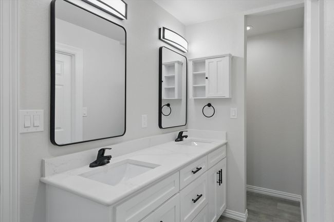 Full bathroom featuring double vanity, baseboards, and wood finished floors | Image 22