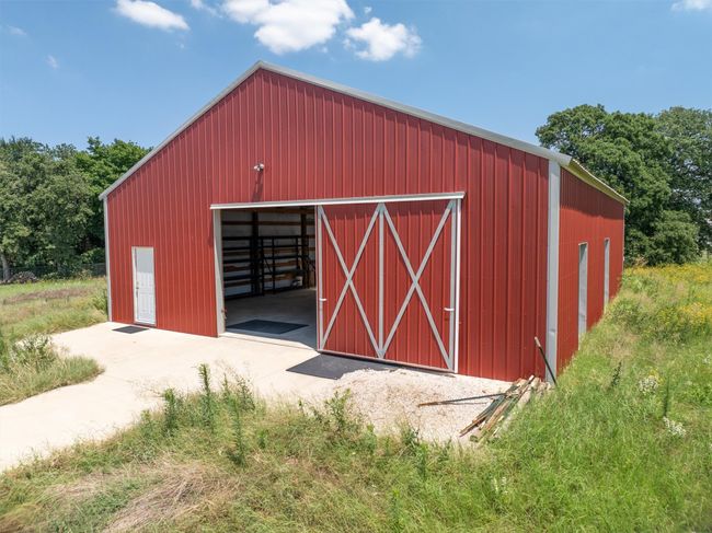 Beautifully crafted red barn offering spacious interiors and traditional appeal, ideal for a variety of uses. | Image 36