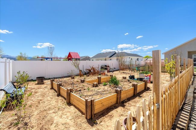 View of yard featuring a fenced backyard and a vegetable garden | Image 64
