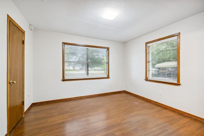 Bedroom #1 large front window. Large closet, vynil flooring, fresh paint, updated light fixture. | Image 22