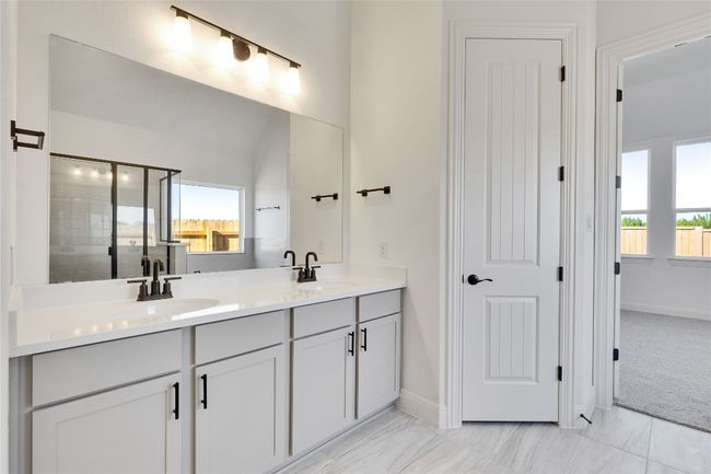 Bathroom featuring baseboards, a sink, and double vanity | Image 7