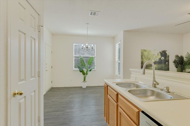 Kitchen with wood-type flooring, light countertops, decorative light fixtures, and a chandelier | Image 14