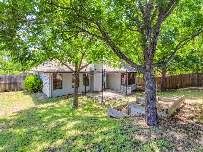 Back of house featuring a fenced backyard, a patio area, and a vegetable garden | Image 6
