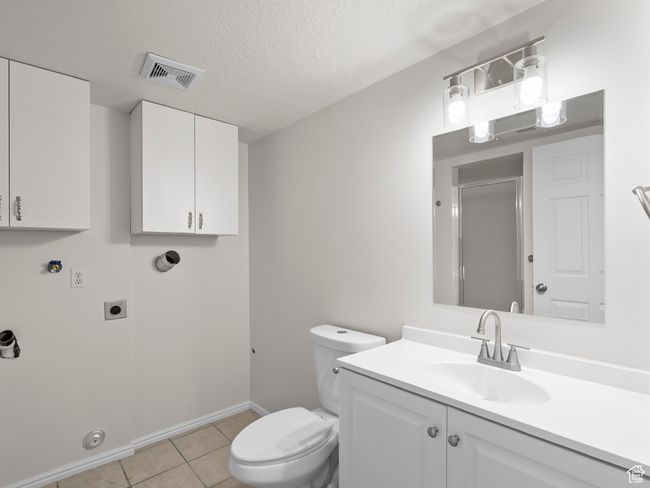 Bathroom featuring toilet, tile patterned floors, a shower with door, baseboards, and vanity | Image 22