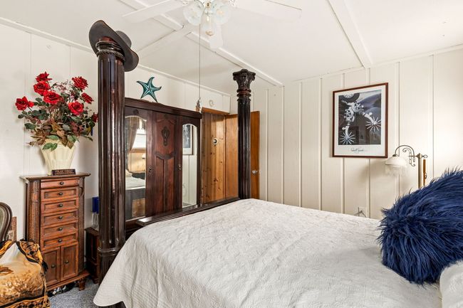 Bedroom with a ceiling fan, a decorative wall, and vaulted ceiling with beams | Image 51