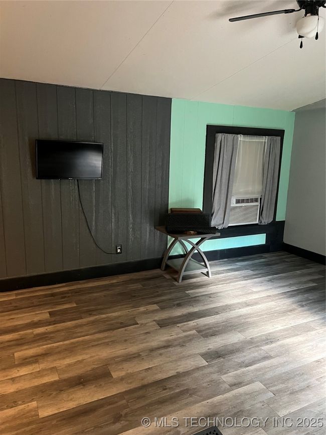 Spare room with wood finished floors, baseboards, a ceiling fan, and cooling unit | Image 4