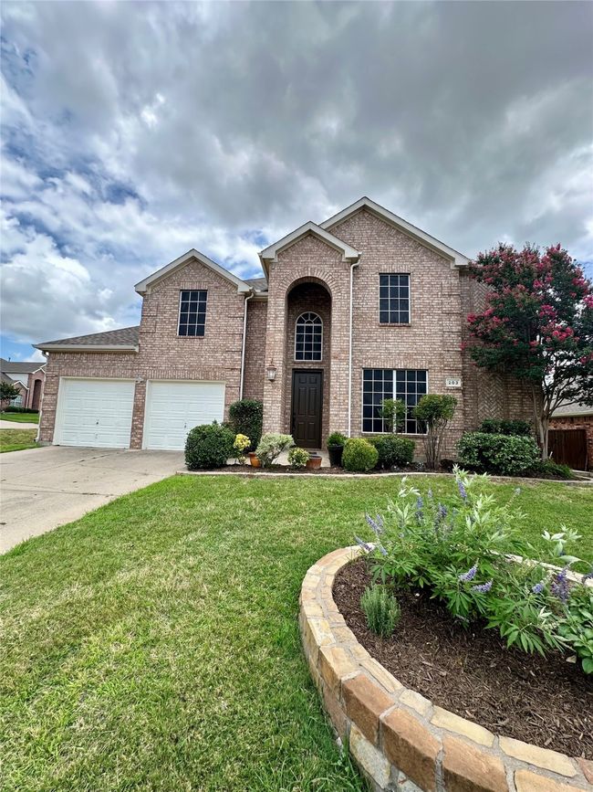 Traditional-style house with brick siding, a front yard, concrete driveway, and an attached garage | Image 26