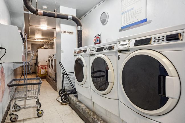 Shared laundry area featuring light tile patterned flooring and washer and clothes dryer | Image 13