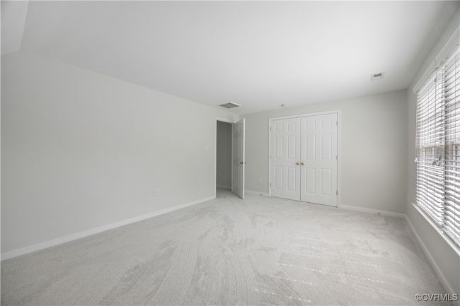 Unfurnished bedroom with baseboards, visible vents, light carpet, and a closet | Image 30