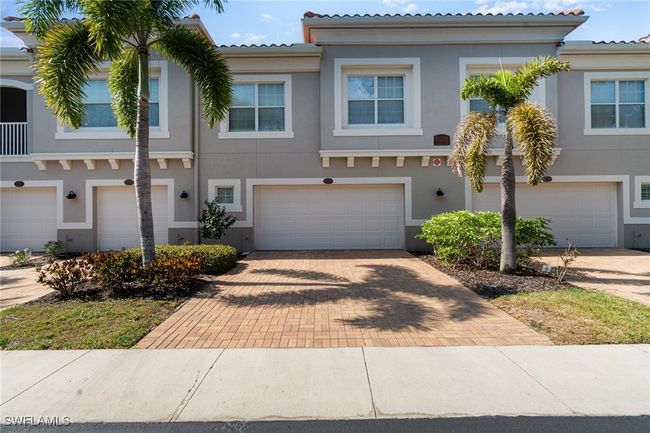 Townhome / multi-family property featuring an attached garage, stucco siding, driveway, and a tile roof | Image 26