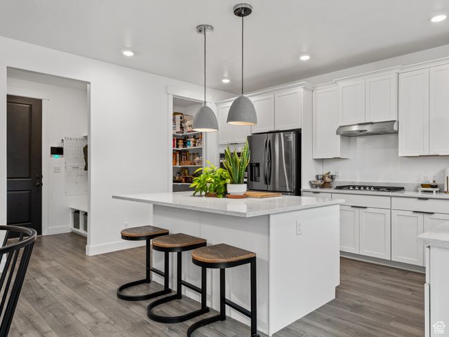 Kitchen with stainless steel appliances, a kitchen island, dark wood-type flooring, white cabinetry, and recessed lighting | Image 25