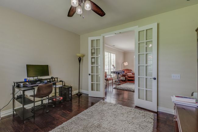 Home office featuring French doors, ceiling fan, wood finished floors. | Image 7