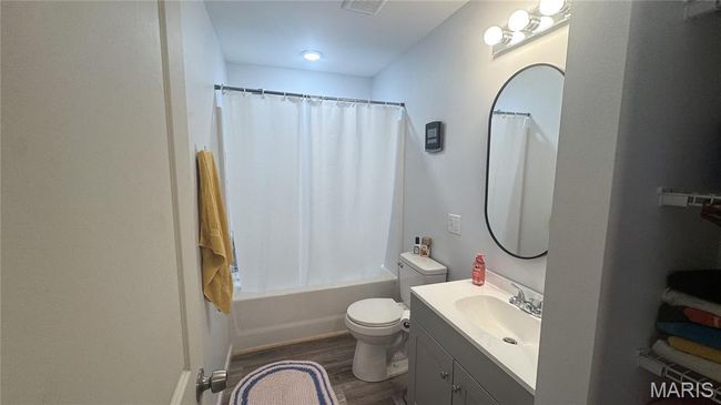 Full bathroom with vanity, wood finished floors, toilet, and shower / bath combination with curtain | Image 6