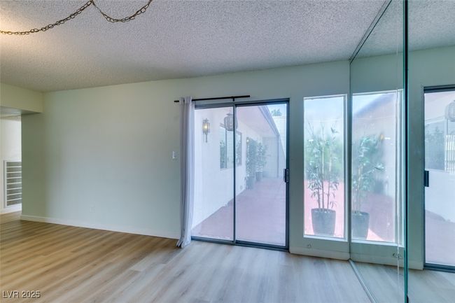 Spare room featuring wood finished floors and a textured ceiling | Image 16