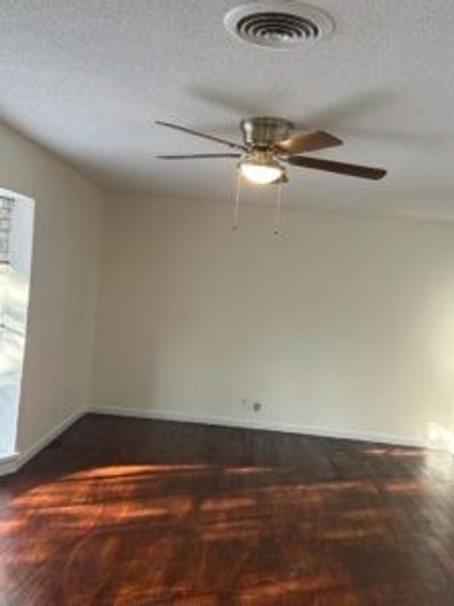 Spare room with ceiling fan and dark wood-style floors | Image 6