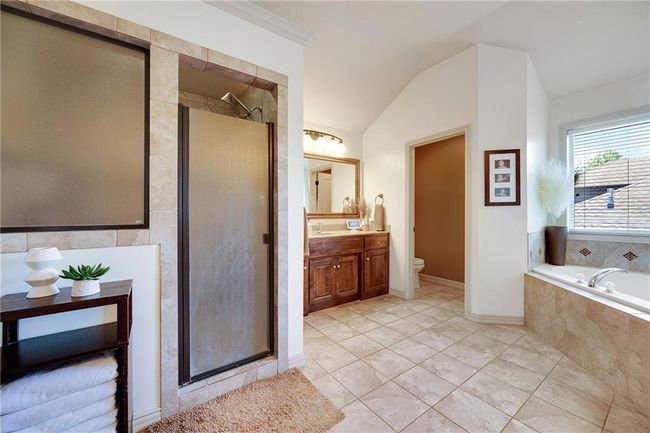 Primary bathroom with tile floors, walk in shower and jacuzzi tub. | Image 30