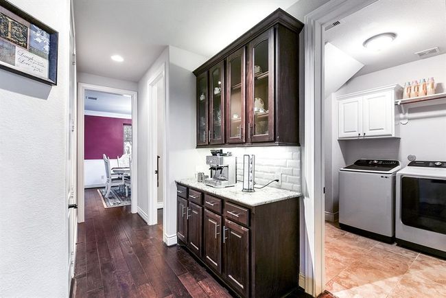 A view from the formal dining room leads seamlessly through the Butler’s Pantry into the kitchen, with convenient access to the large utility room and walk in pantry. This layout offers both functionality and flow, making it perfect for meal prep and organization. | Image 44